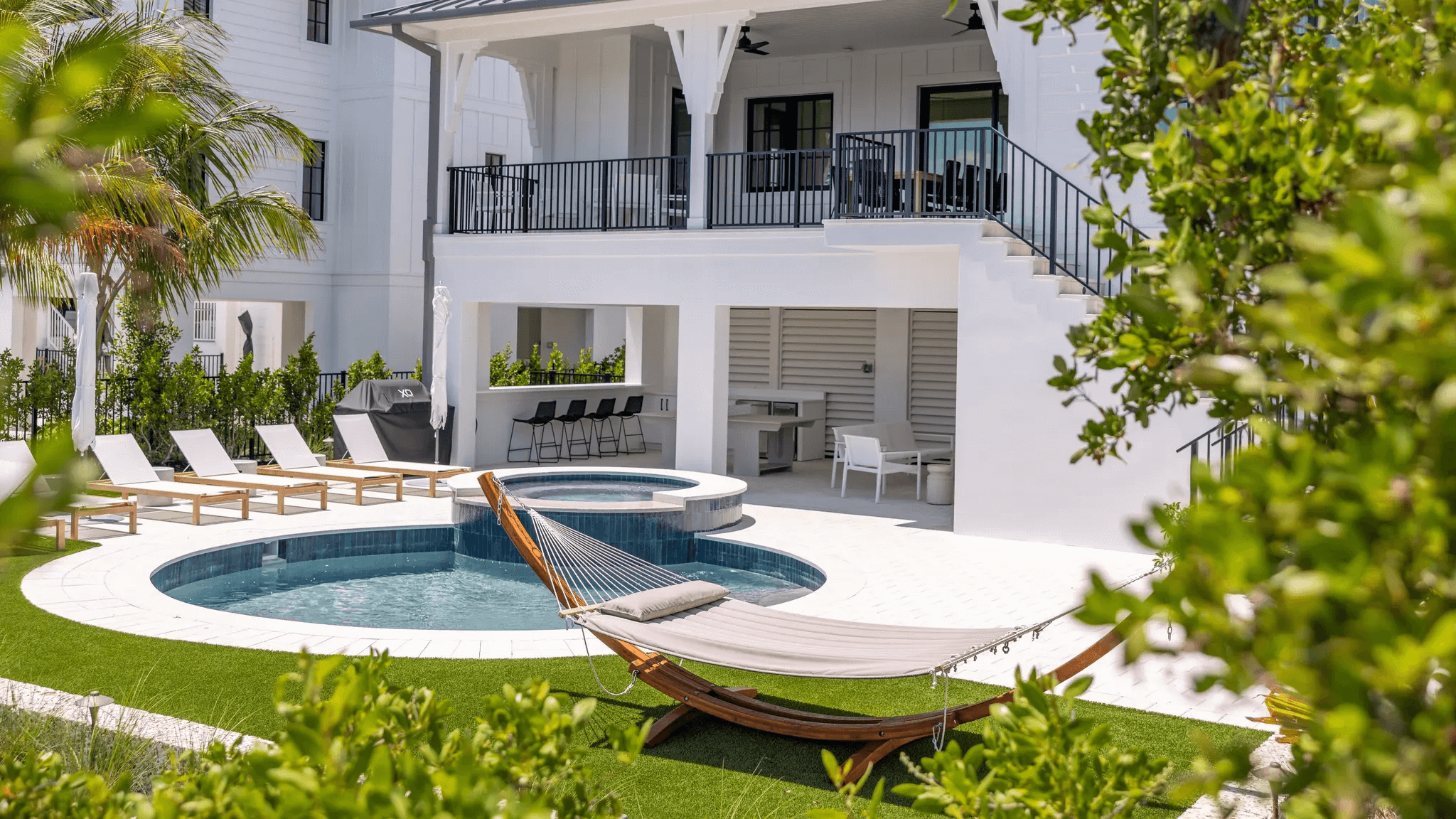 Modern backyard with pool and hammock.
