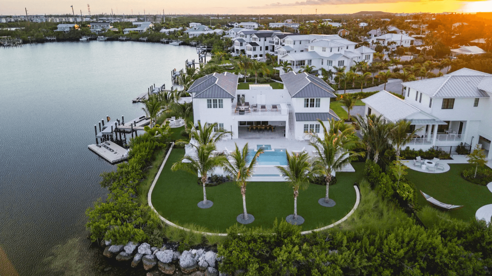 Waterfront luxury home with pool and greenery.