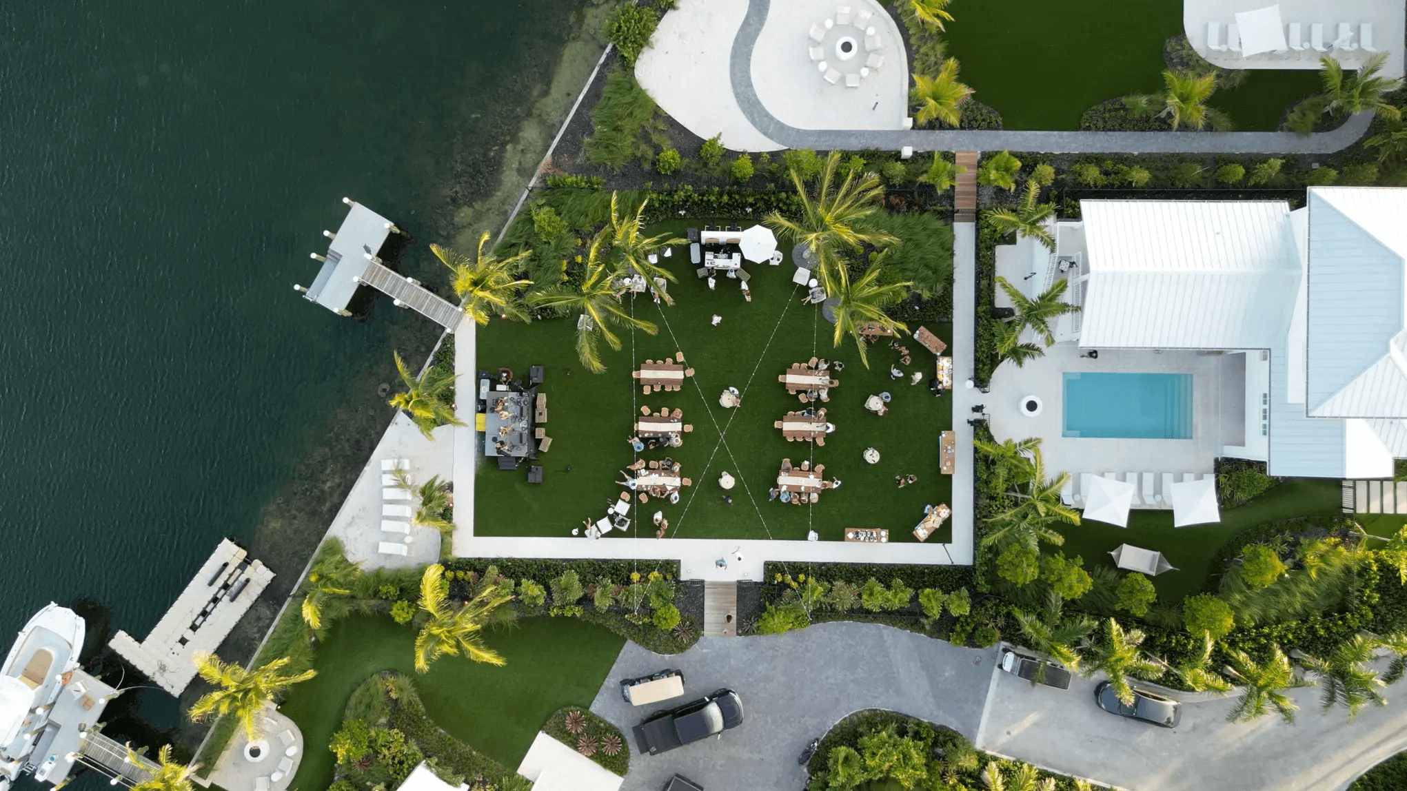 Aerial view of waterfront garden event setup.