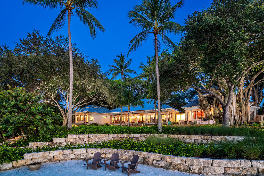 Tropical beachfront house with palm trees.