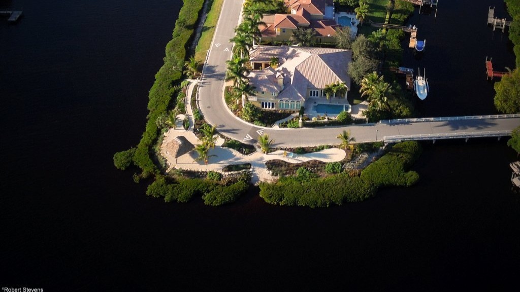 Aerial view of waterfront homes and road.