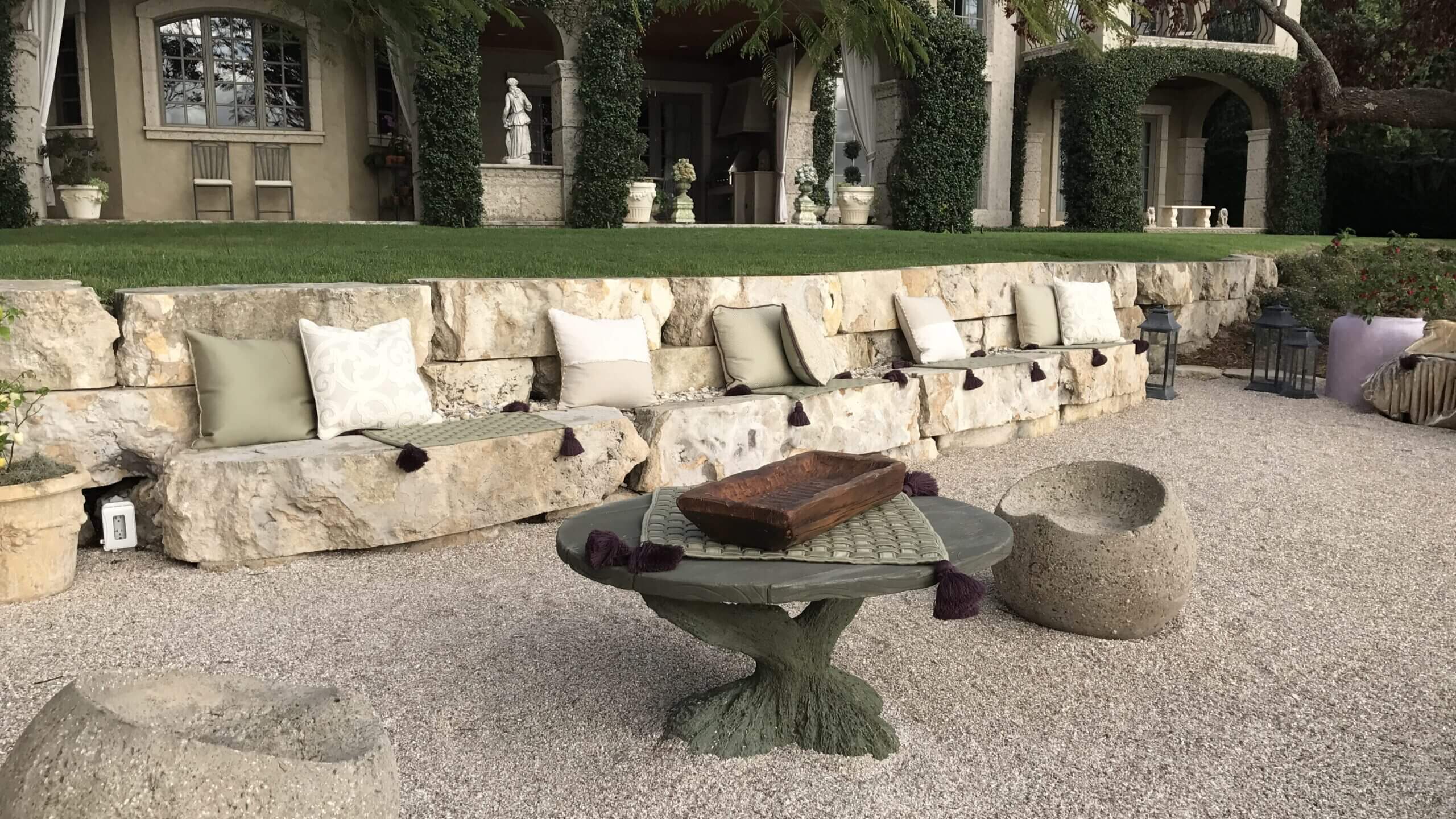 Stone patio with seating and round table.
