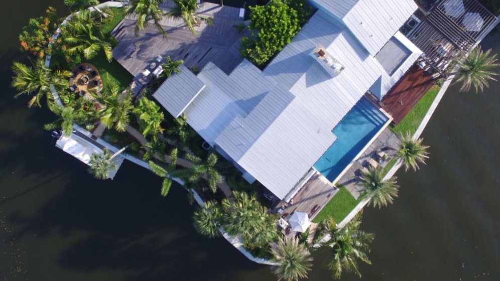 Aerial view of waterfront house with pool.