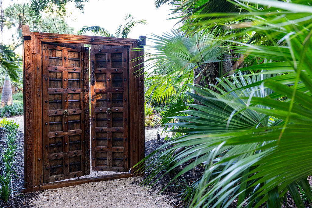Wooden garden gate surrounded by lush greenery.