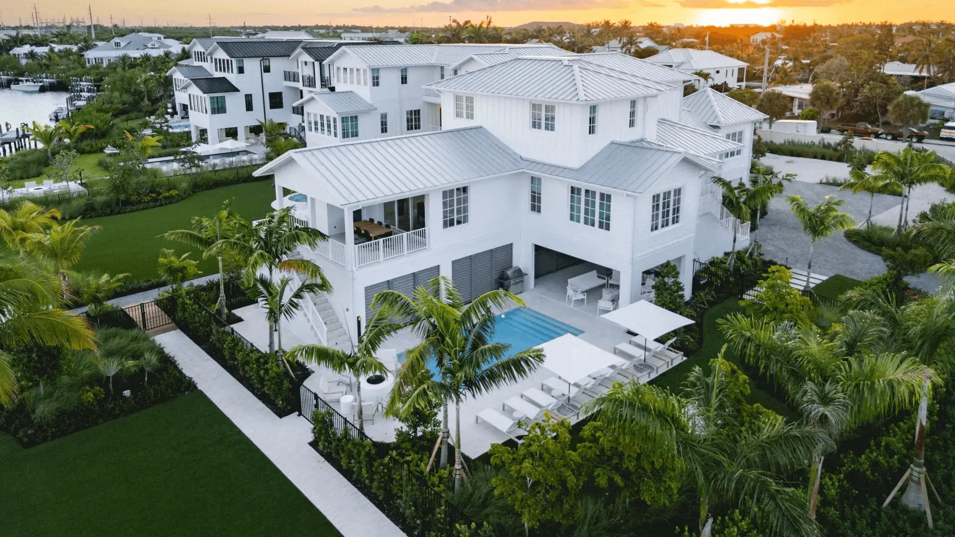 Large white house with pool and garden.
