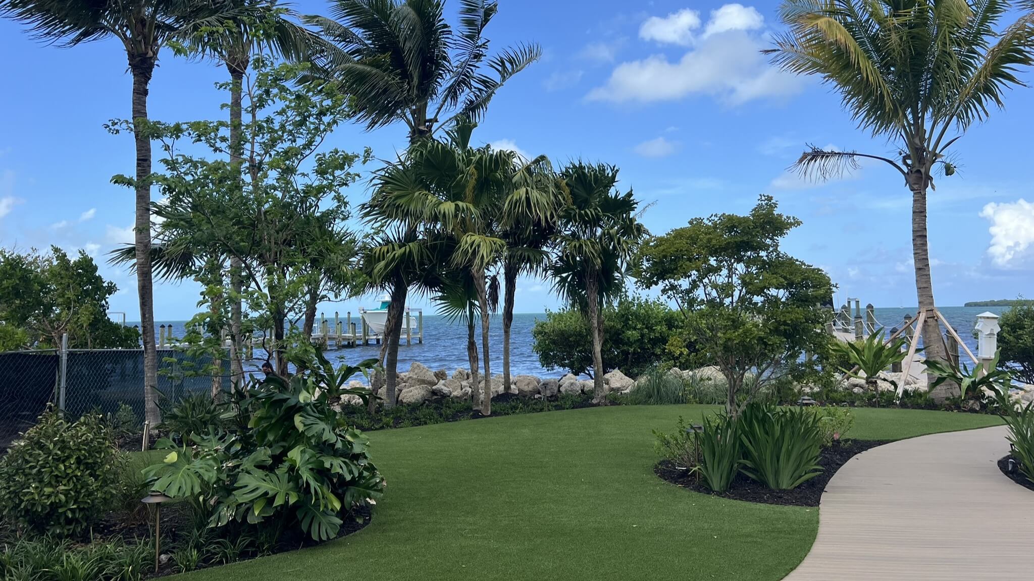 Tropical garden with ocean view and pathway.