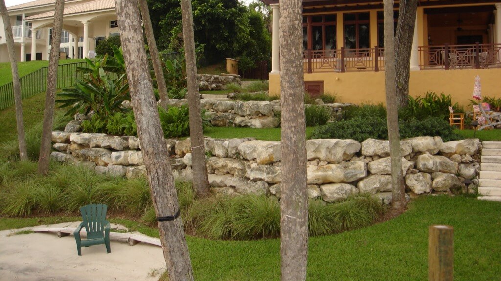 Garden with stone wall and trees.
