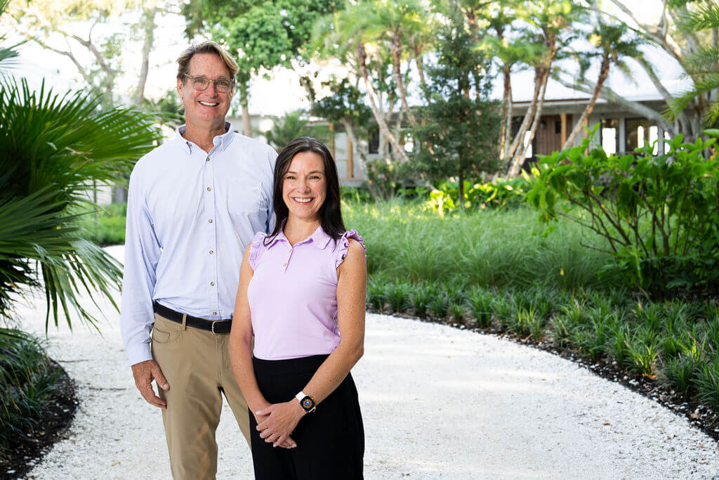 Smiling couple standing on a garden path.