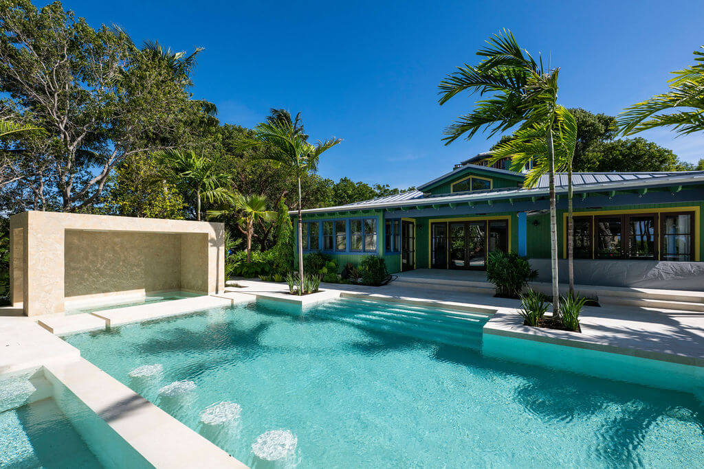 Tropical house with pool and palm trees.