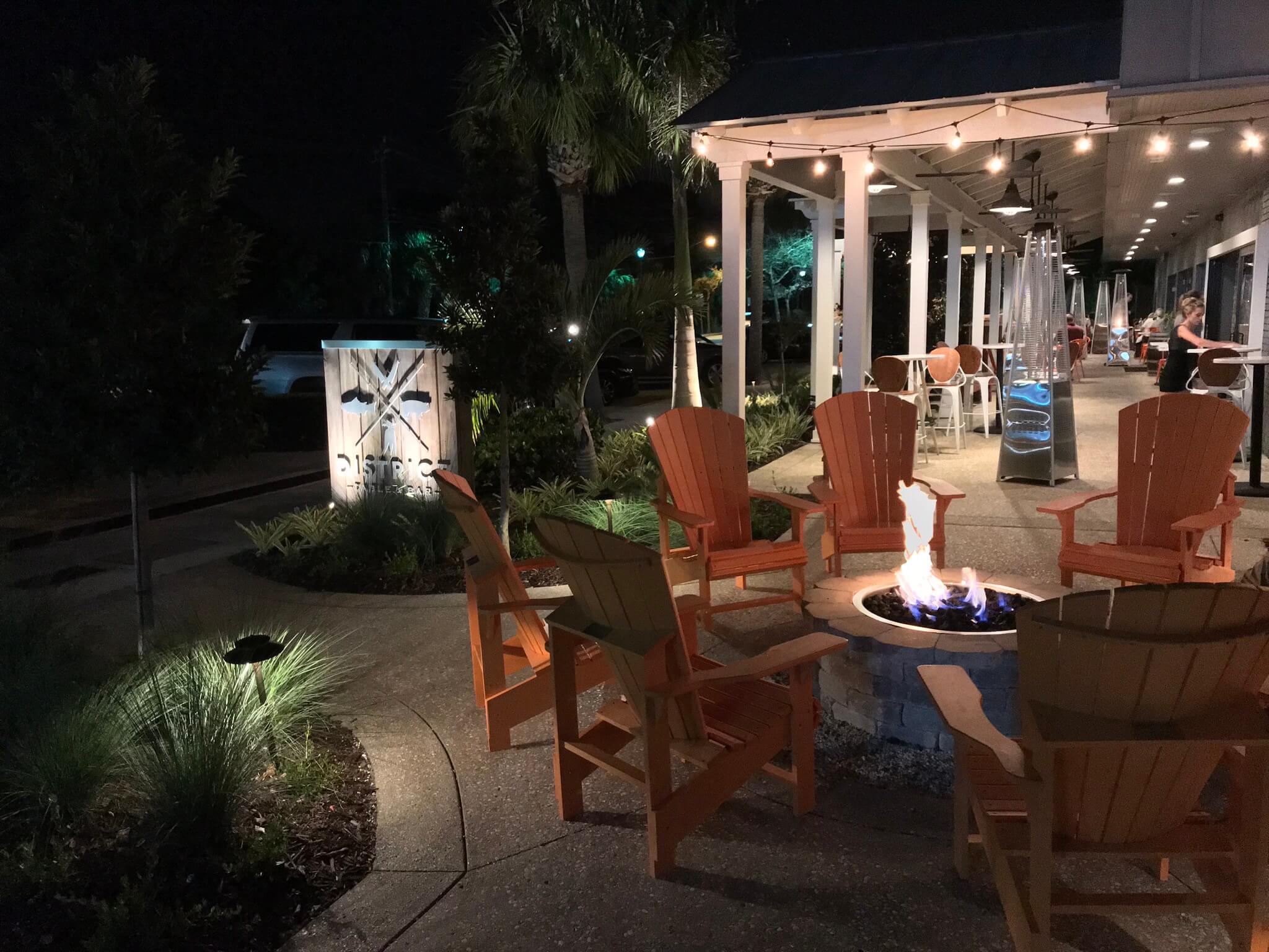 Outdoor seating around a fire pit at night.